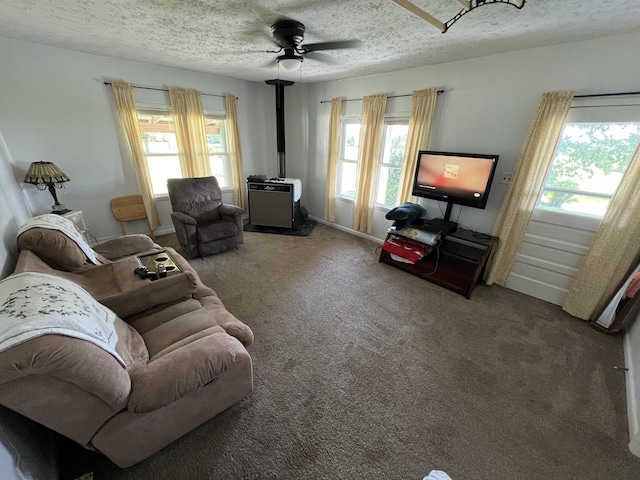 carpeted living room with ceiling fan and a textured ceiling