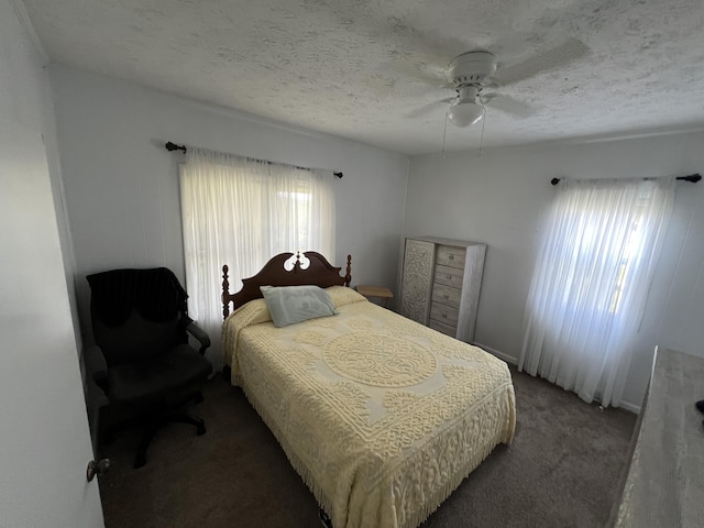 carpeted bedroom featuring a textured ceiling, ceiling fan, and multiple windows