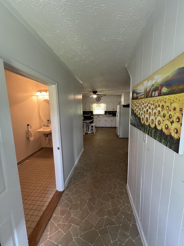 corridor with a textured ceiling and dark tile patterned floors