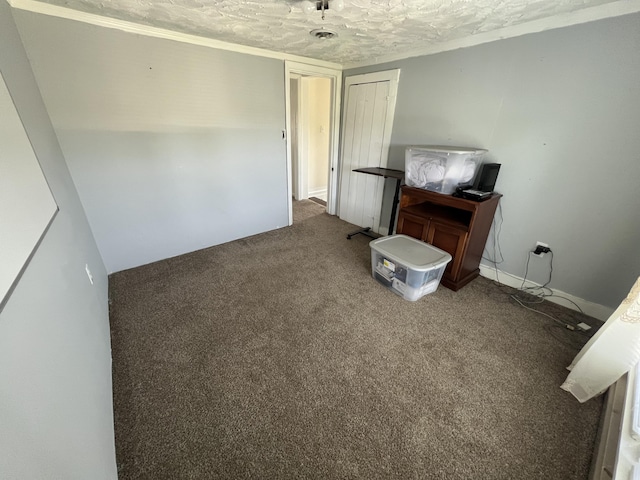 interior space with a textured ceiling and carpet flooring