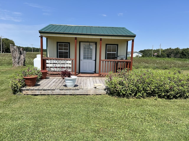 exterior space featuring a front lawn, an outbuilding, and a wooden deck