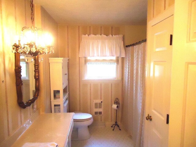 bathroom featuring vanity, toilet, and a chandelier