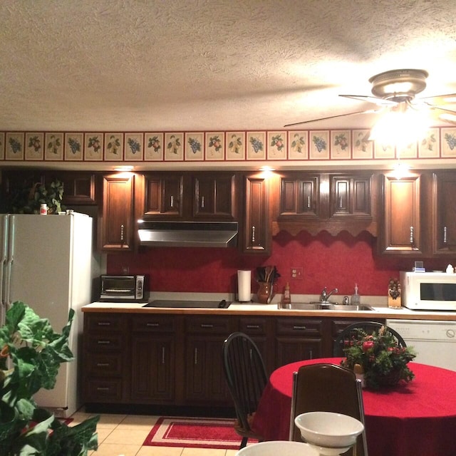 kitchen with white appliances, dark brown cabinets, light tile patterned floors, sink, and ceiling fan