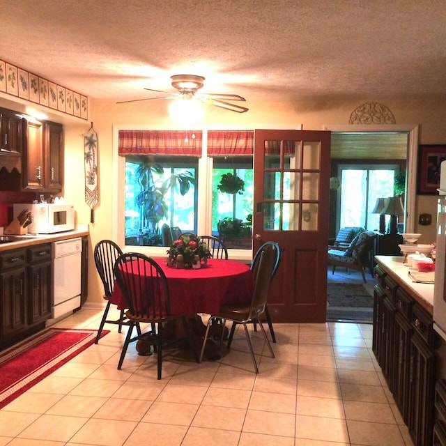 tiled dining room featuring ceiling fan and a textured ceiling