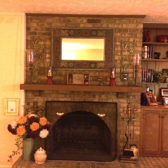 interior details featuring a brick fireplace