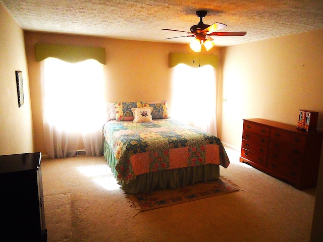 bedroom featuring ceiling fan, carpet, and a textured ceiling