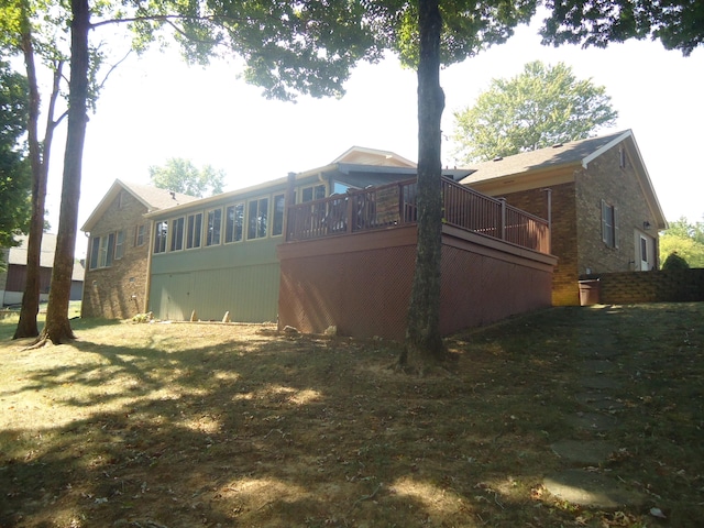 view of property exterior with a lawn and a wooden deck