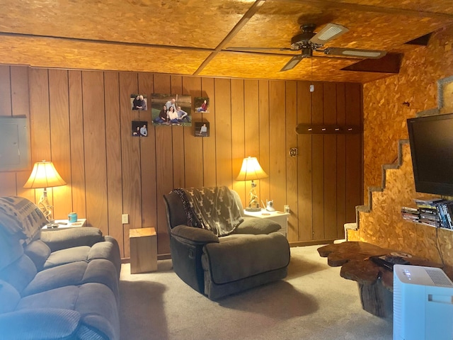 carpeted living room featuring wood walls, electric panel, and ceiling fan