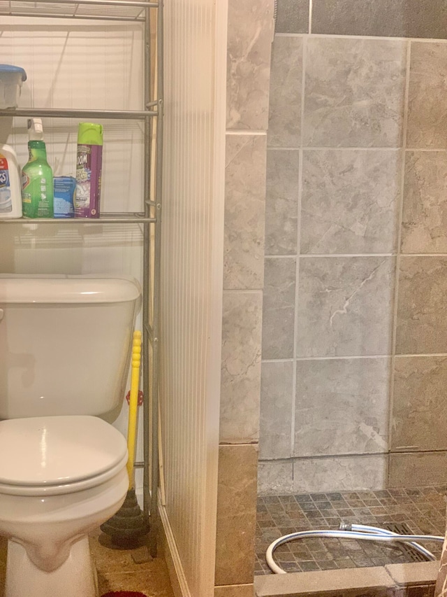 bathroom featuring walk in shower, tile patterned floors, and toilet