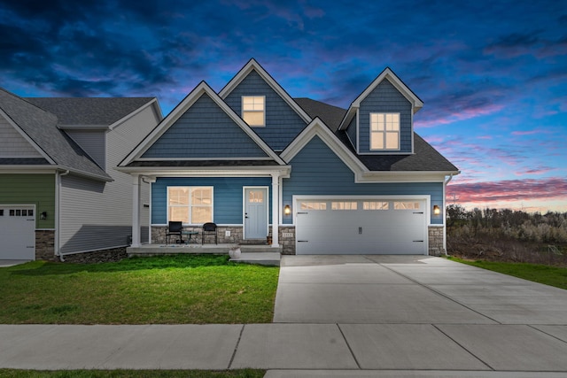 craftsman-style house featuring stone siding, covered porch, driveway, and a front lawn