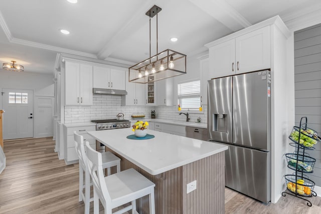 kitchen featuring tasteful backsplash, appliances with stainless steel finishes, and light wood-style floors