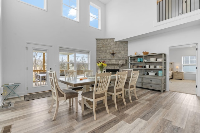 dining room featuring visible vents, a fireplace, and wood finished floors