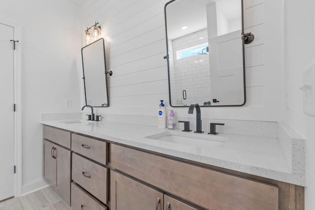 bathroom with double vanity, a sink, and a shower stall