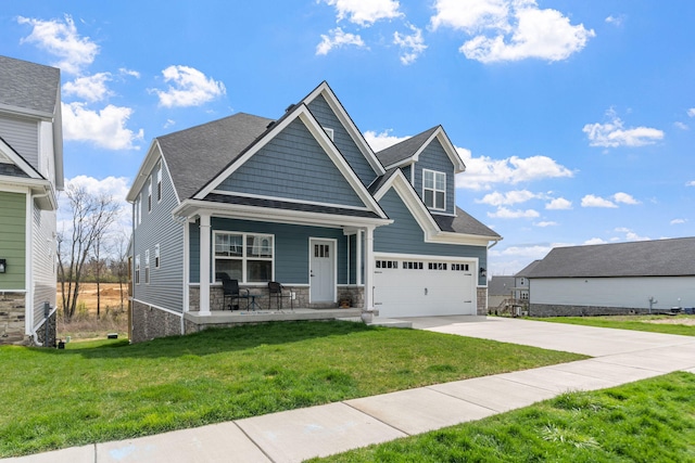 view of front of house featuring a porch, concrete driveway, a front lawn, and stone siding