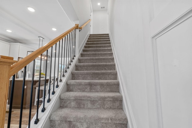 stairway with baseboards, visible vents, and recessed lighting