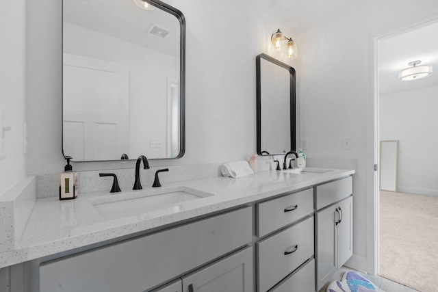 bathroom with double vanity, visible vents, and a sink