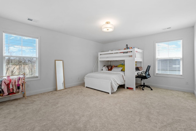 carpeted bedroom with visible vents and baseboards