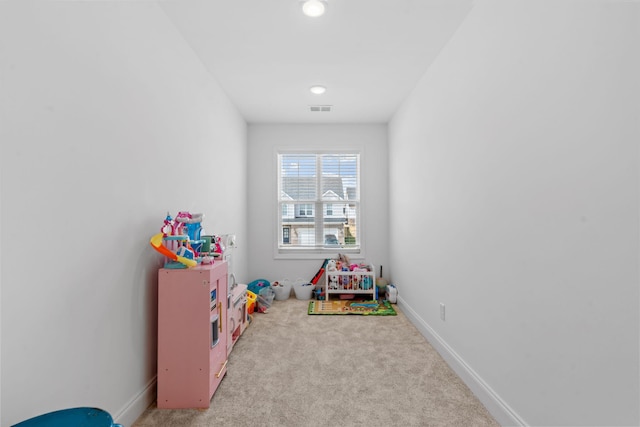 recreation room with carpet, visible vents, and baseboards