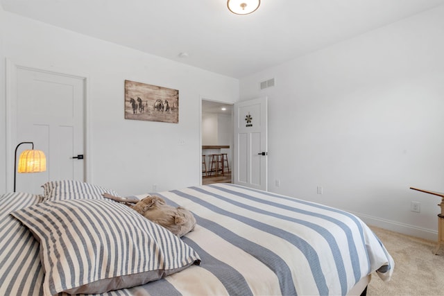 bedroom with visible vents, light carpet, and baseboards