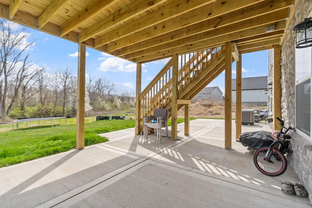 view of patio featuring stairs, central AC unit, and a trampoline