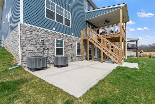 rear view of property featuring a ceiling fan, a patio area, central AC, and a yard