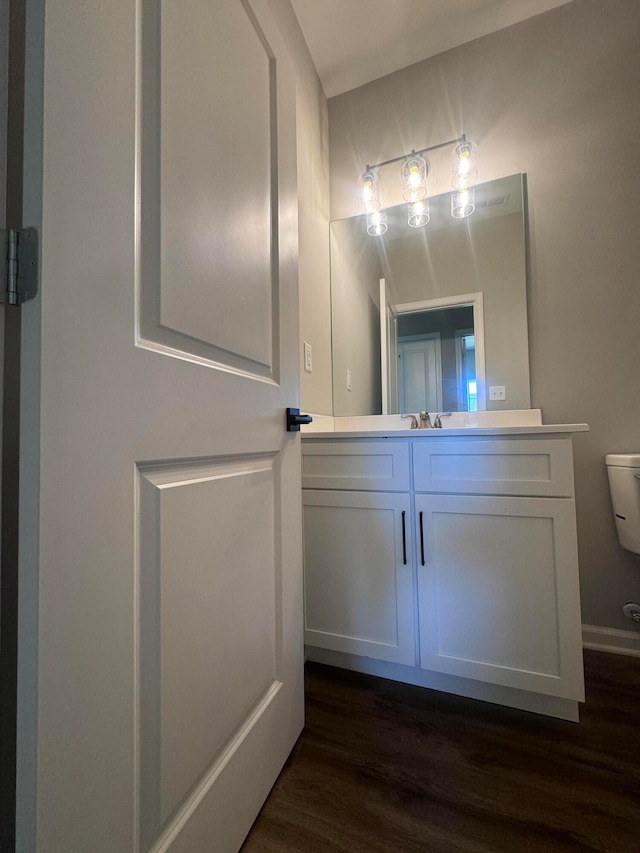 bathroom with vanity, hardwood / wood-style flooring, and toilet