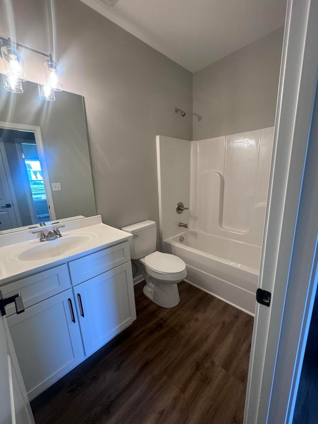 full bathroom with vanity, toilet, wood-type flooring, and tub / shower combination