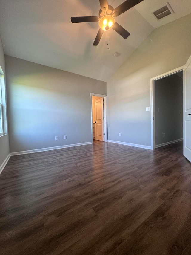 empty room with vaulted ceiling, ceiling fan, and dark hardwood / wood-style flooring