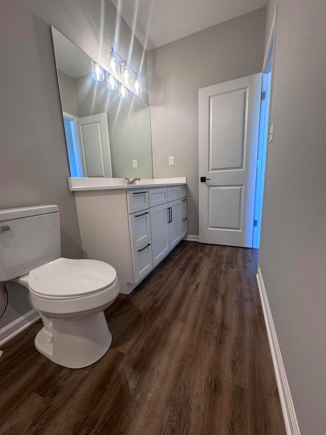 bathroom with vanity, toilet, and wood-type flooring