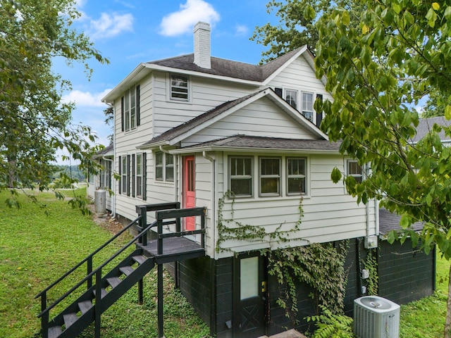 view of front of house featuring a front lawn and central AC