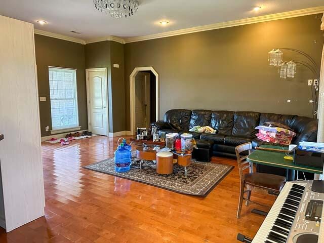 living room featuring hardwood / wood-style floors and crown molding