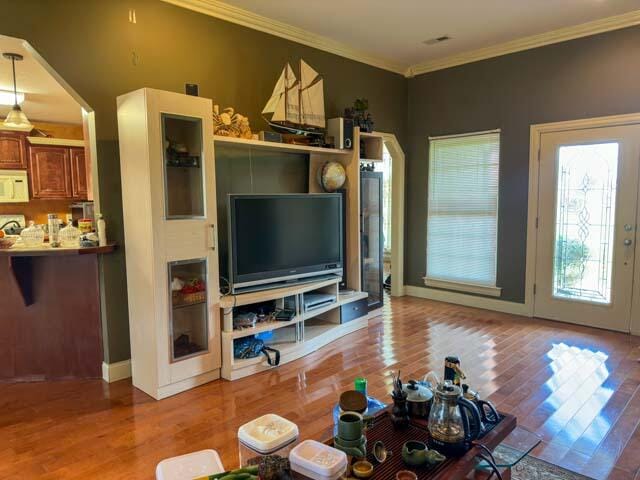 living room with ornamental molding and hardwood / wood-style floors