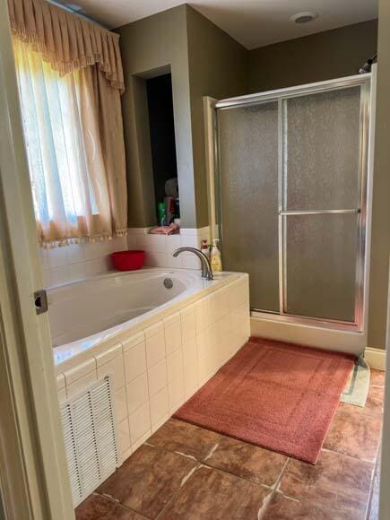 bathroom with tile patterned flooring and separate shower and tub