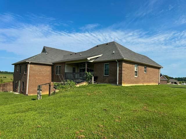 rear view of house featuring a lawn