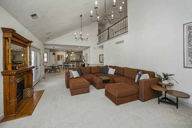 living room featuring high vaulted ceiling, a chandelier, and light carpet