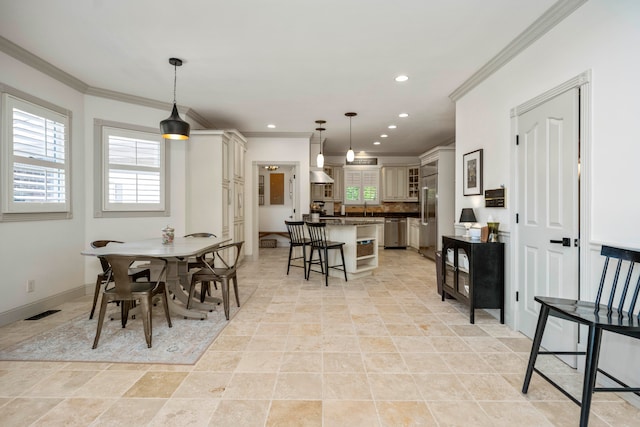 dining room with sink, crown molding, and light tile patterned floors