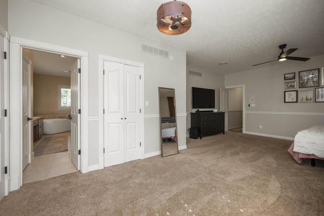 unfurnished bedroom featuring carpet, visible vents, a textured ceiling, and ensuite bathroom