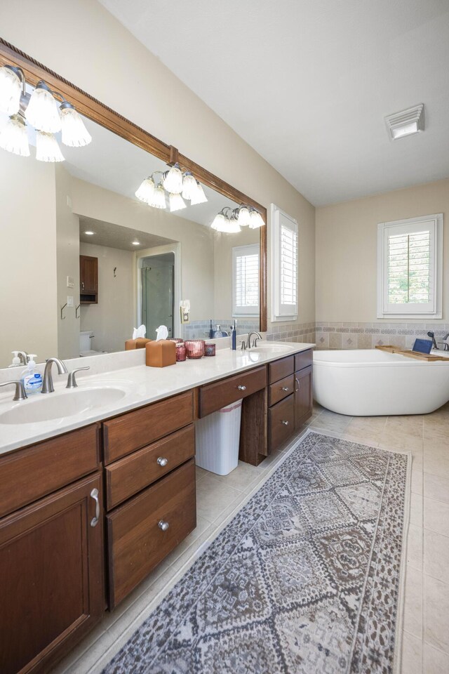 bathroom featuring tile patterned floors, vanity, and a tub to relax in