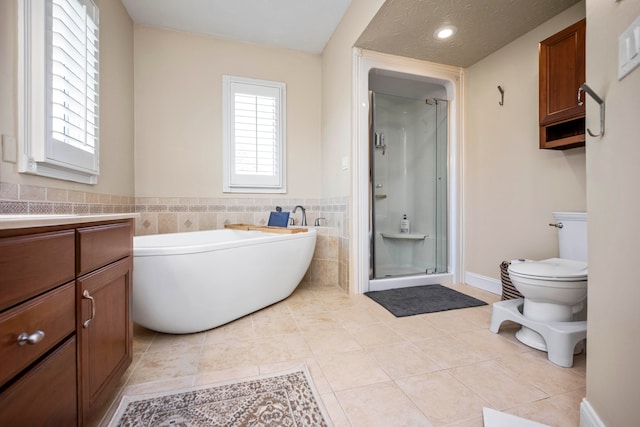 full bathroom featuring tile walls, tile patterned floors, plus walk in shower, and vanity