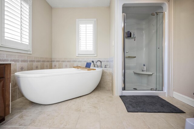 bathroom featuring plus walk in shower, vanity, tile patterned floors, and tile walls