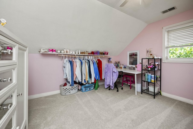 walk in closet with lofted ceiling, carpet flooring, visible vents, and a ceiling fan