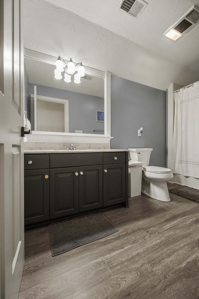 bathroom featuring toilet, visible vents, wood finished floors, and vanity