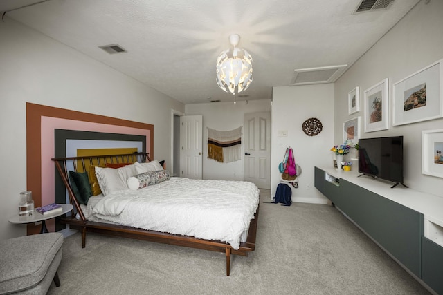 carpeted bedroom featuring attic access, a textured ceiling, visible vents, and baseboards