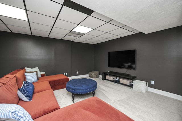 carpeted living room featuring a paneled ceiling and baseboards