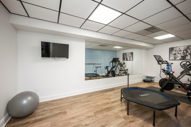 workout room featuring light hardwood / wood-style floors and a paneled ceiling