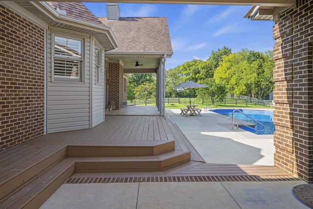 wooden deck with outdoor dining space, fence, and a fenced in pool