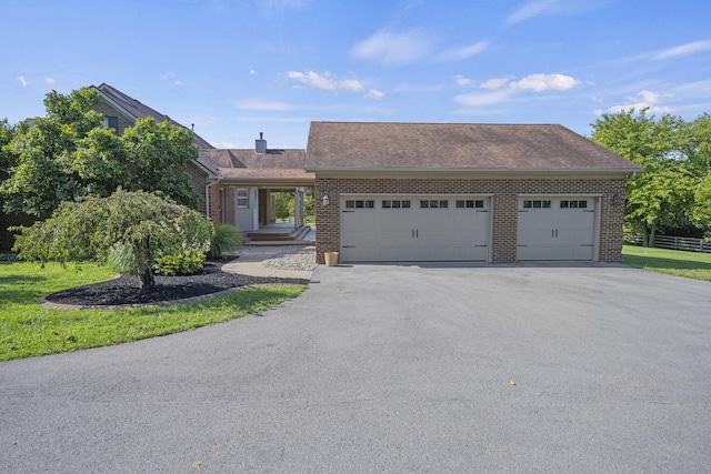 view of front of home with an attached garage, fence, aphalt driveway, and brick siding