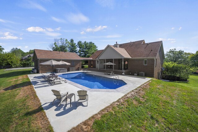 view of swimming pool featuring a patio area and a yard