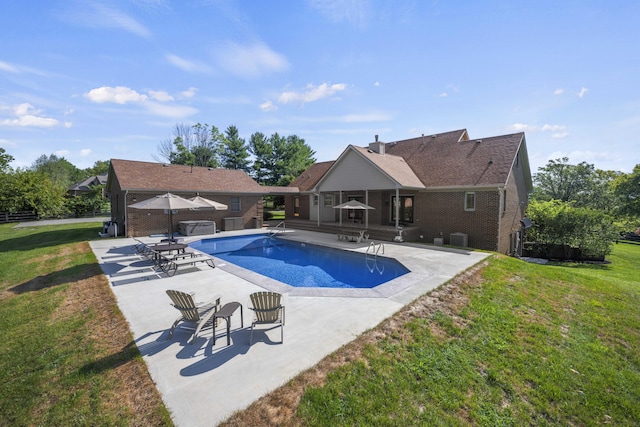 outdoor pool featuring a patio area and a yard