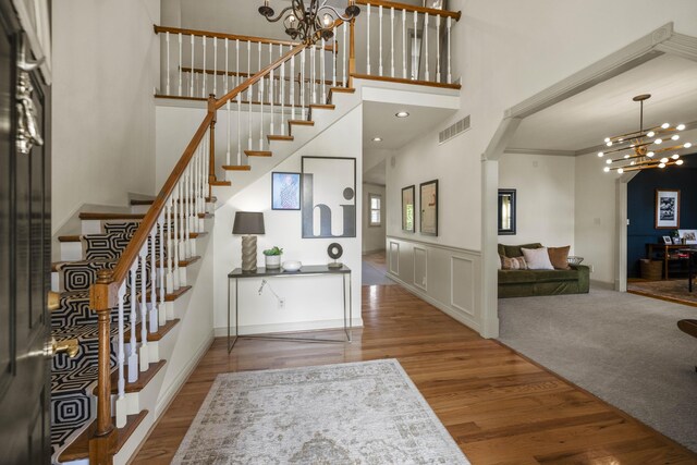 entrance foyer featuring a high ceiling, wood-type flooring, and a chandelier